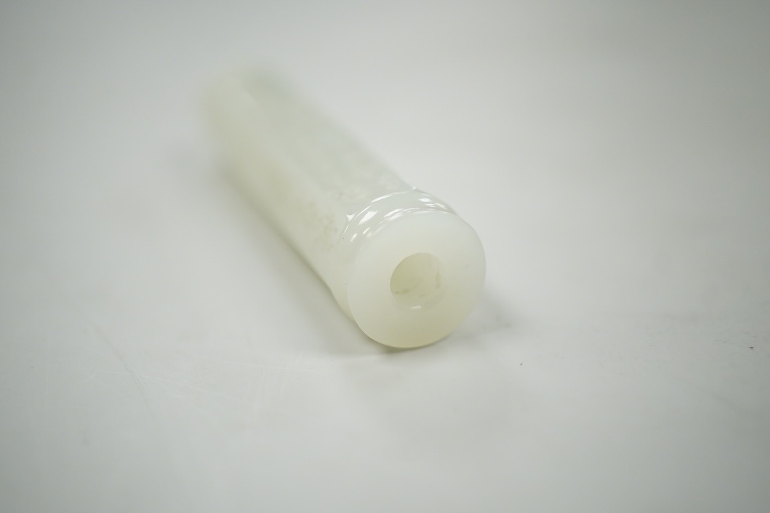 A Chinese pale celadon jade inscribed cylinder bead, 6.5cm long